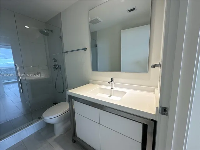 a bathroom with a granite countertop toilet sink and shower