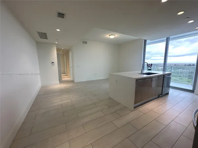 a kitchen with granite countertop a refrigerator and a sink