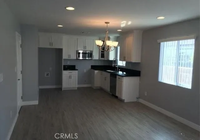 a kitchen with stainless steel appliances granite countertop a refrigerator a sink dishwasher a stove and a refrigerator