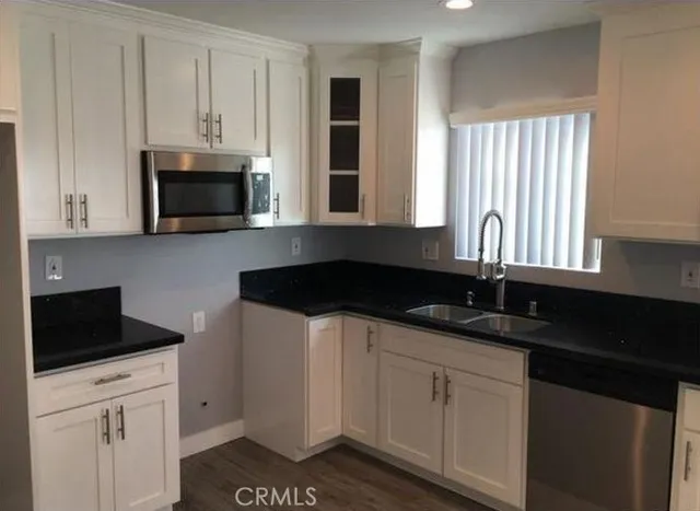 a kitchen with granite countertop white cabinets and a stove