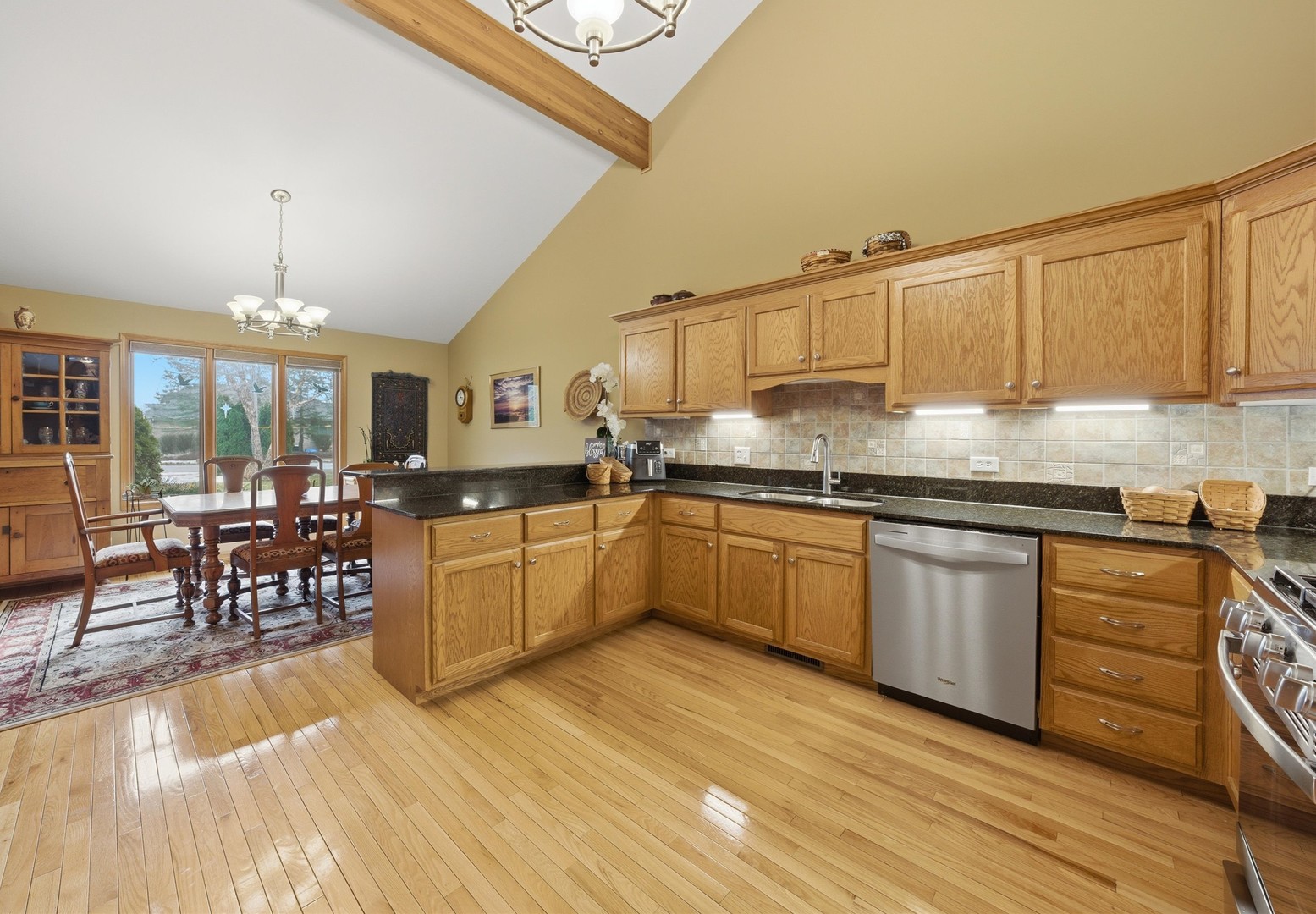 3688 Warwick Drive Crete, IL 60417 - Photo 11 of 27 a kitchen with granite countertop a stove a sink a dining table and chairs with wooden floor