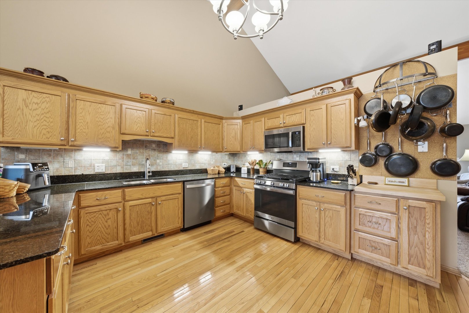 3688 Warwick Drive Crete, IL 60417 - Photo 9 of 27 a kitchen with stainless steel appliances granite countertop a sink dishwasher a stove top oven a dining table and chairs with wooden floor