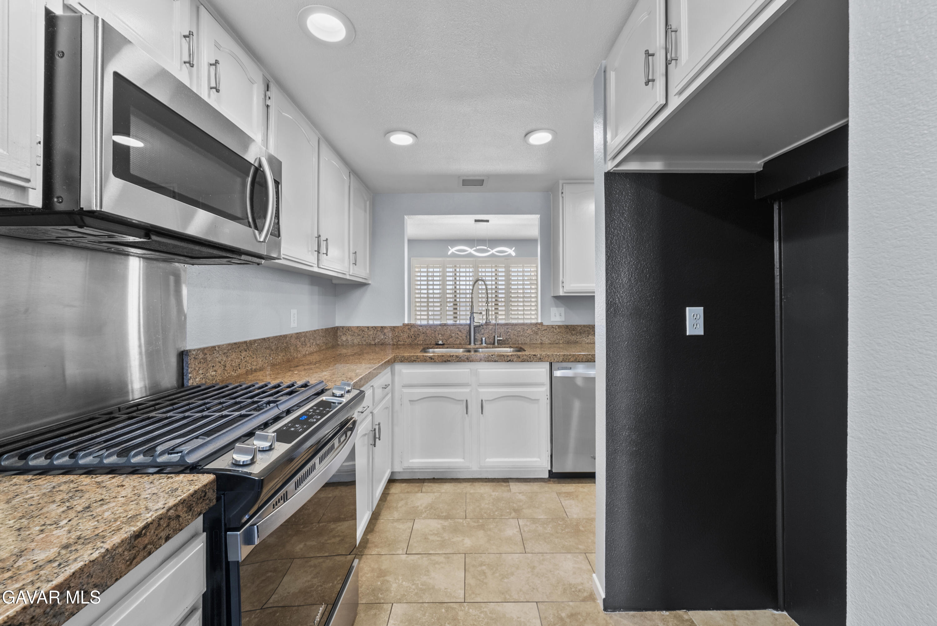 42805 15th Street West Lancaster, CA 93534 - Photo 12 of 27 a kitchen with stainless steel appliances granite countertop a stove and a microwave