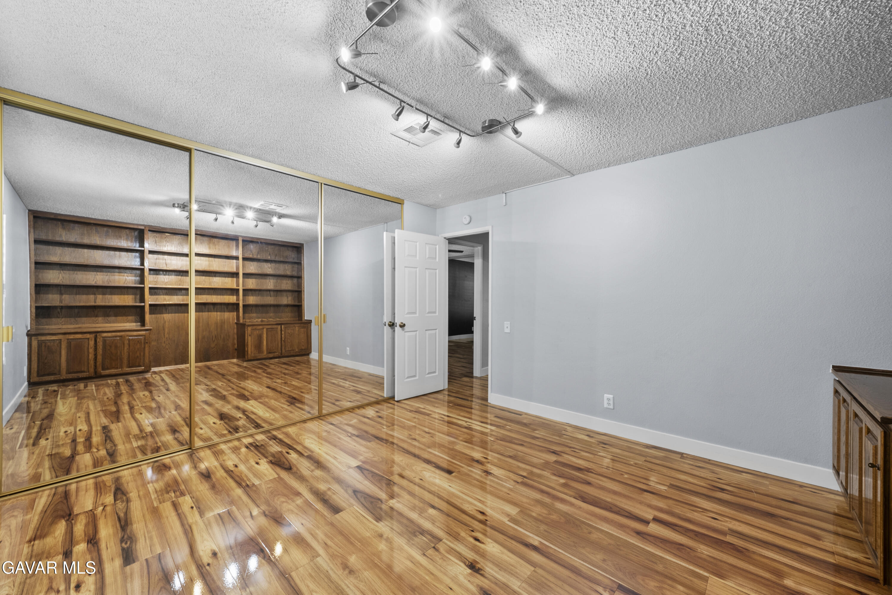 42805 15th Street West Lancaster, CA 93534 - Photo 16 of 27 a view of an empty room with wooden floor and a ceiling fan
