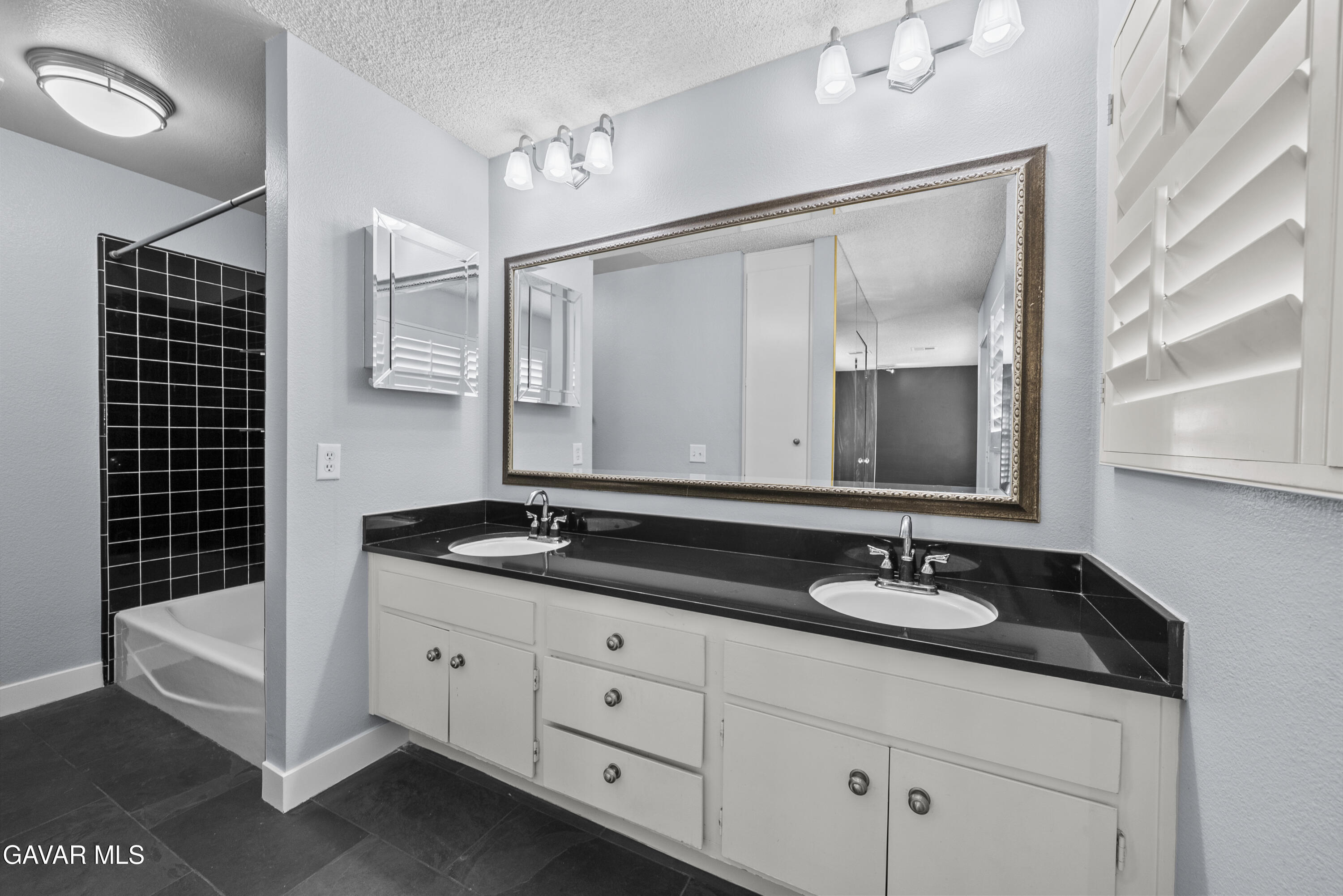 42805 15th Street West Lancaster, CA 93534 - Photo 25 of 27 a bathroom with a granite countertop sink mirror and double