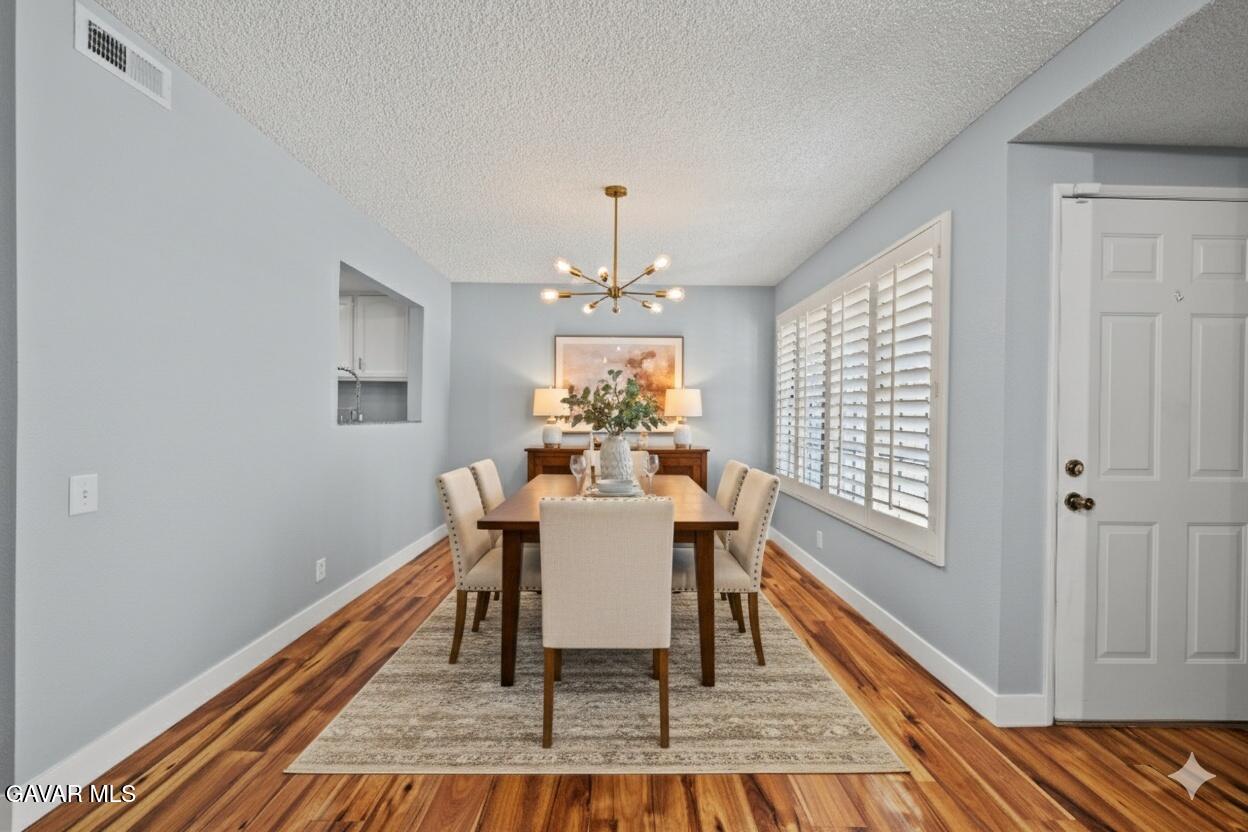 42805 15th Street West Lancaster, CA 93534 - Photo 3 of 27 a dining room with furniture a chandelier and wooden floor