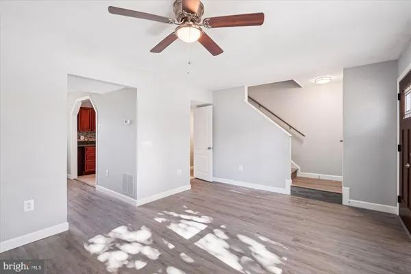 wooden floor in an empty room with a fan