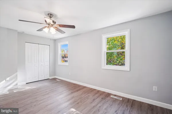 an empty room with windows and closet