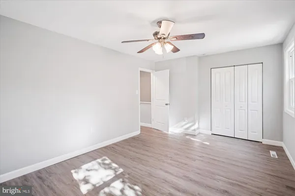 an empty room with wooden floor and mirror