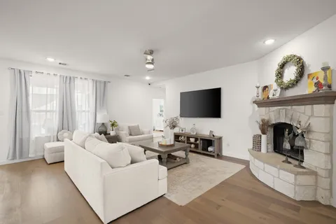 a living room with furniture a fireplace and a flat screen tv