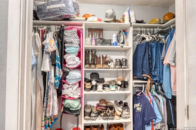 a view of walk in closet with clothes and shoes