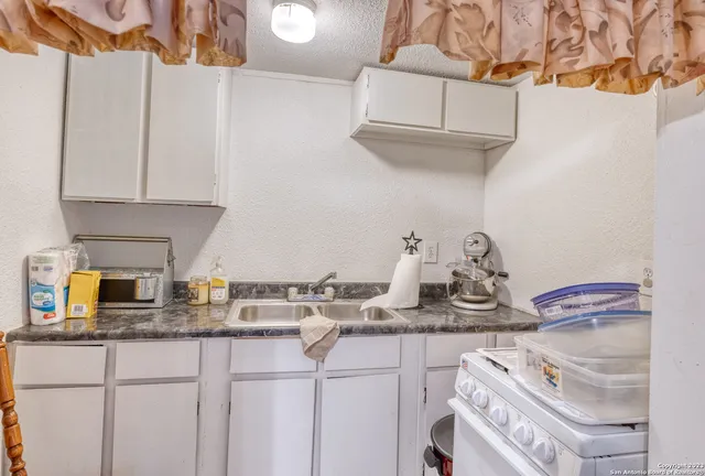 a kitchen with white cabinets and a sink