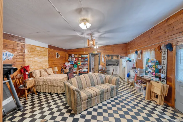 a living room with patio furniture and a chandelier