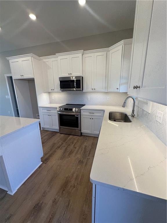 5207 Lee Road Salem, AL 36874 - Photo 4 of 23 Kitchen featuring white cabinetry, stainless steel stove, decorative backsplash, light stone counters, and recessed lighting