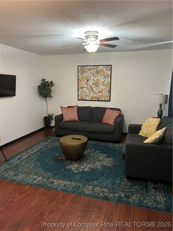 a living room with furniture a chandelier and a rug