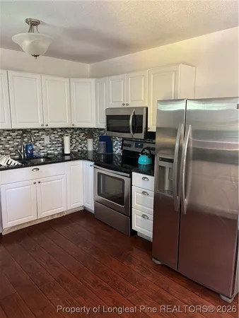 a kitchen with stainless steel appliances kitchen island granite countertop a refrigerator and a stove top oven