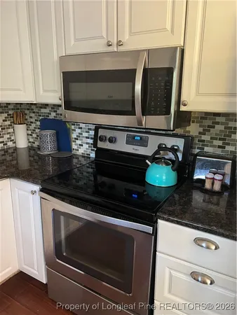 a kitchen with granite countertop a stove and a microwave