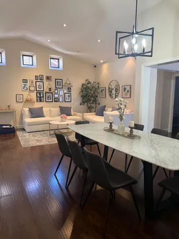 a view of a dining room with furniture a chandelier and wooden floor