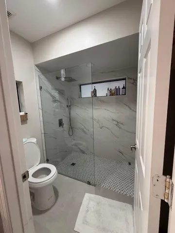a bathroom with a toilet and a shower