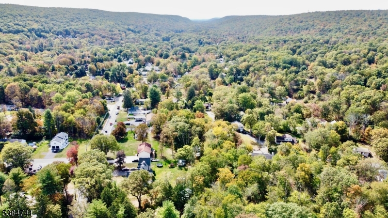 5327 Berkshire Valley Road, Unit 5 Oak Ridge, NJ 07438 - Photo 30 of 32 an aerial view of a houses with a lush green hillside and some trees