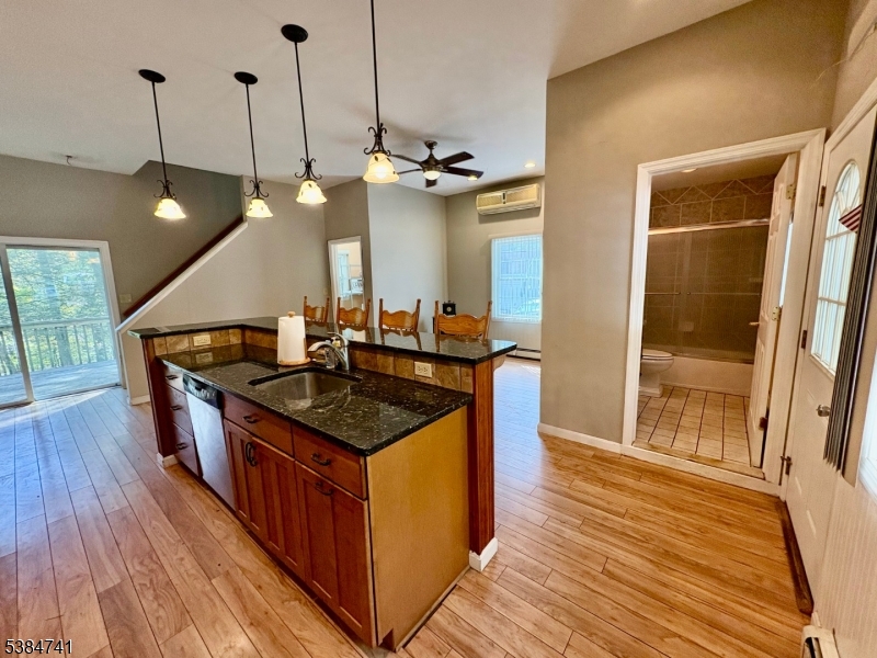 5327 Berkshire Valley Road, Unit 5 Oak Ridge, NJ 07438 - Photo 7 of 32 a kitchen with stainless steel appliances granite countertop a sink a counter space and wooden floor