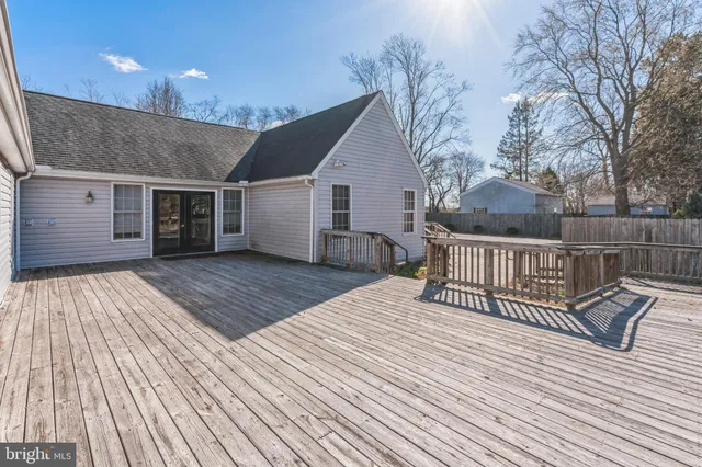 a view of a house with wooden deck and a backyard