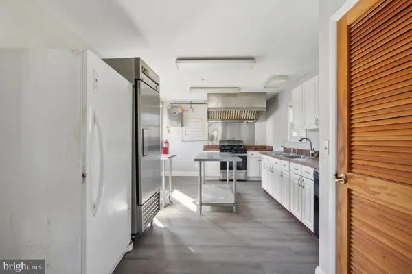 a kitchen with stainless steel appliances kitchen island granite countertop a refrigerator and a stove top oven