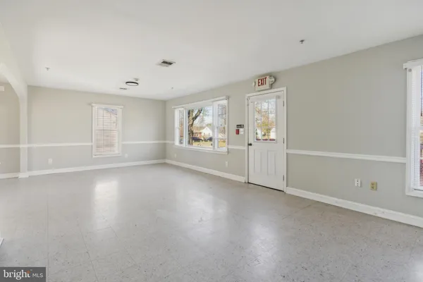 an empty room with windows and fireplace