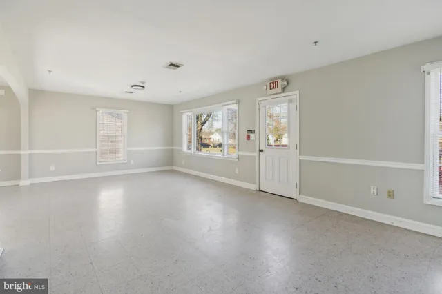 an empty room with windows and fireplace
