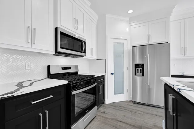 a kitchen with stainless steel appliances a stove microwave and a refrigerator