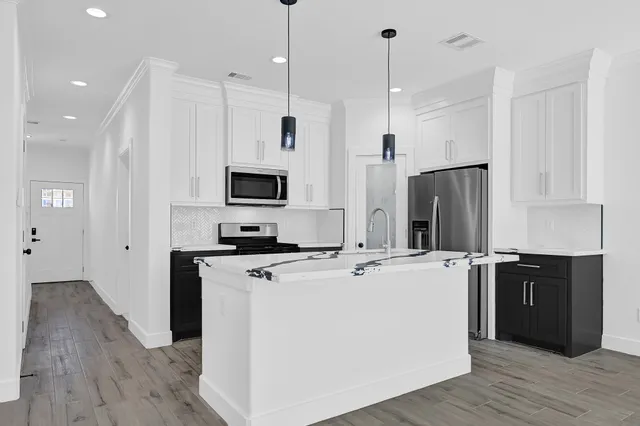 a kitchen with a stove a sink and a refrigerator