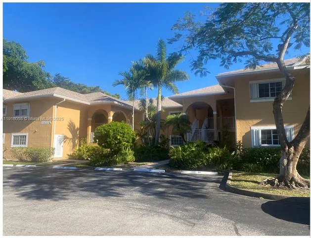 a view of a house with potted plants and a fountain