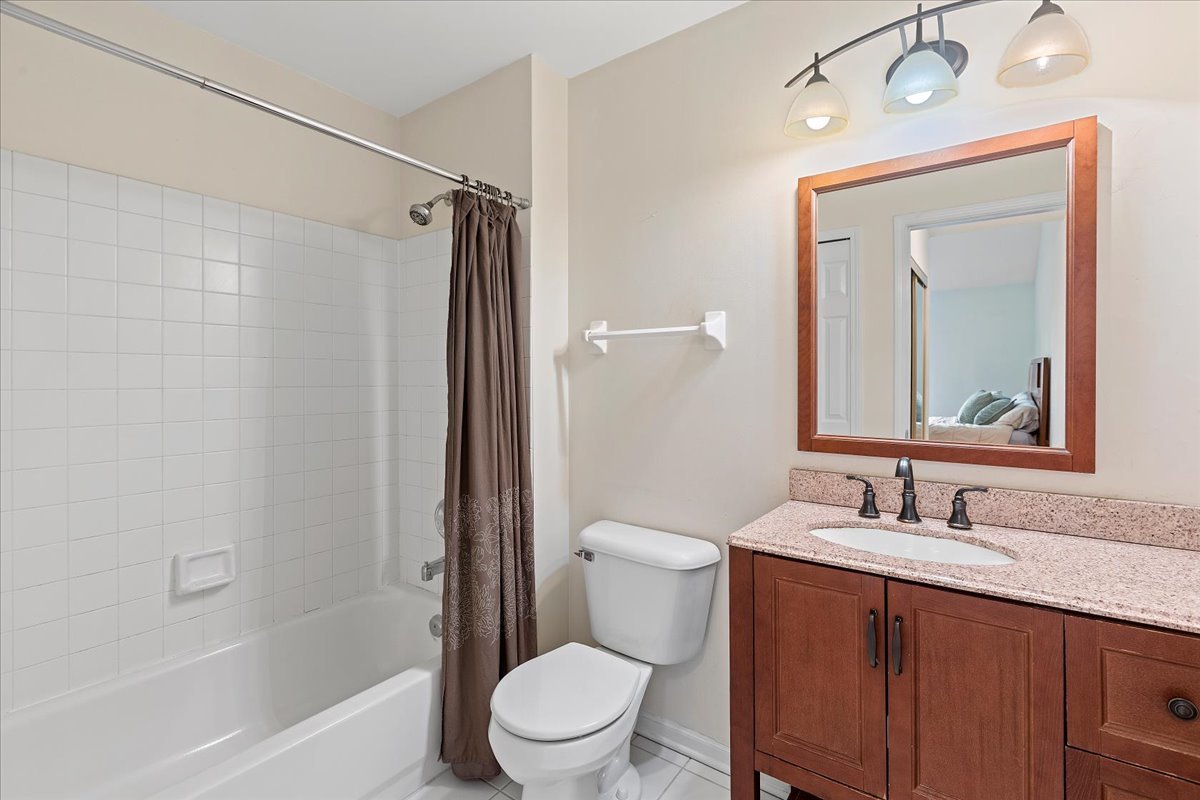 962 Willow Street Itasca, IL 60143 - Photo 26 of 33 a bathroom with a granite countertop toilet a sink and a bathtub