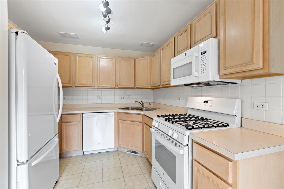 962 Willow Street Itasca, IL 60143 - Photo 6 of 33 a kitchen with stainless steel appliances granite countertop a stove a sink and a refrigerator