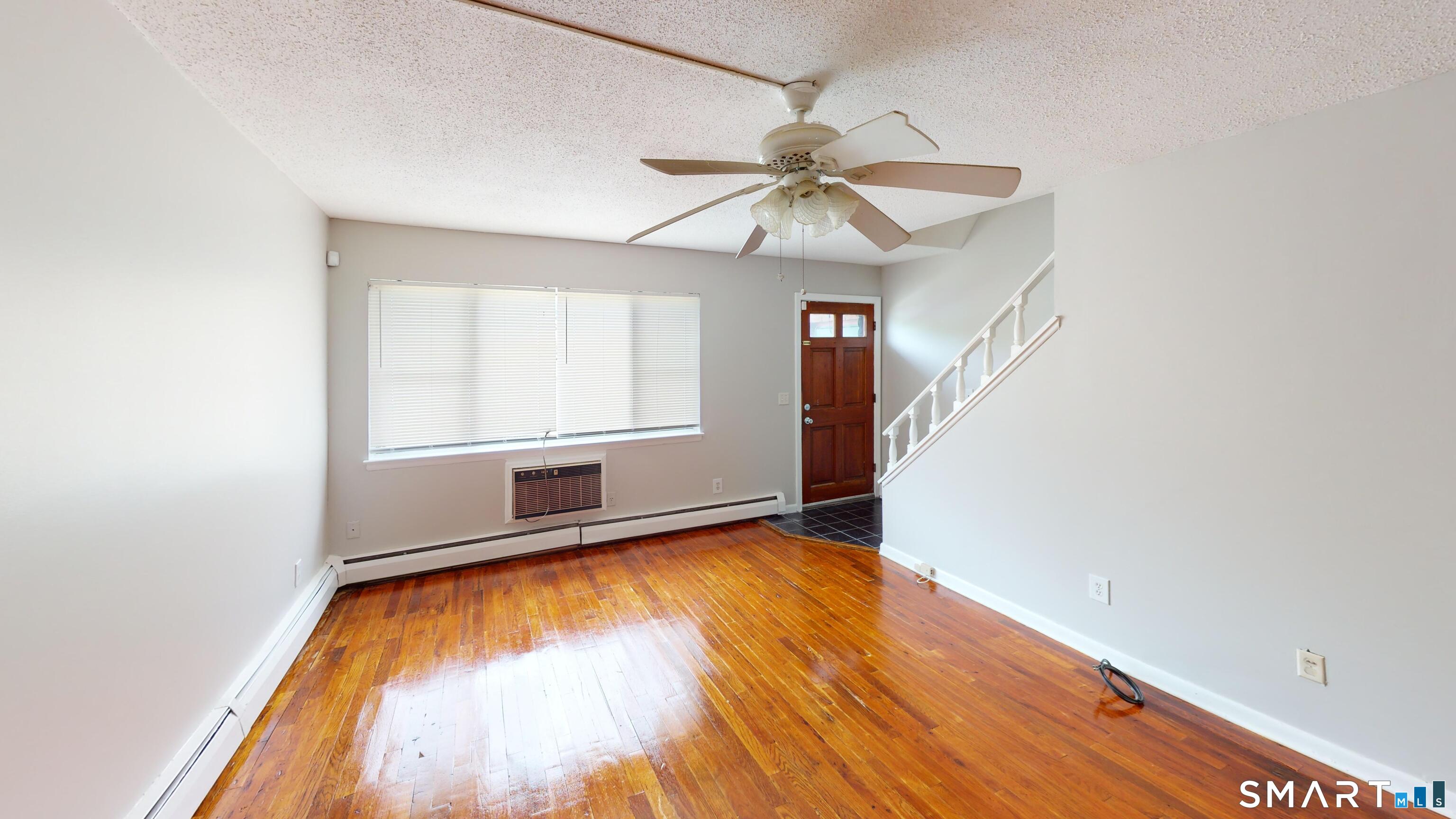 158 High Path Road, Unit 158 Windsor, CT 06095 - Photo 2 of 20 an empty room with wooden floor fan and windows