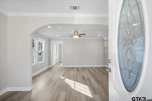 a view of a livingroom with wooden floor and a ceiling fan