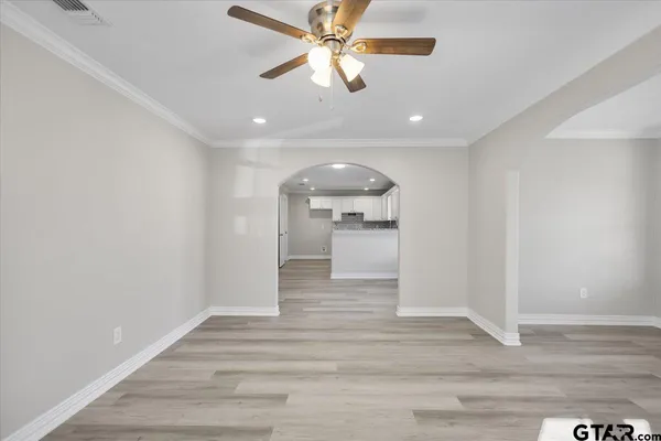 a view of a hallway with wooden floor and a ceiling fan