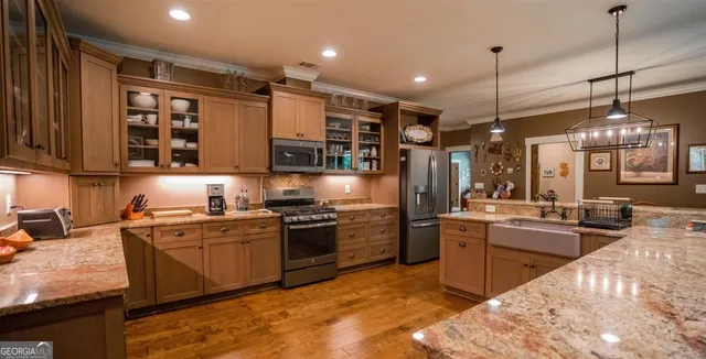 a kitchen with stainless steel appliances granite countertop wooden cabinets stove top oven and sink