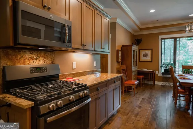 a kitchen with kitchen island granite countertop a sink stove and cabinets