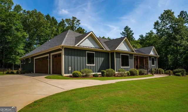 a front view of a house with a garden and trees