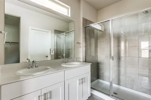 a bathroom with a shower sink vanity and mirror