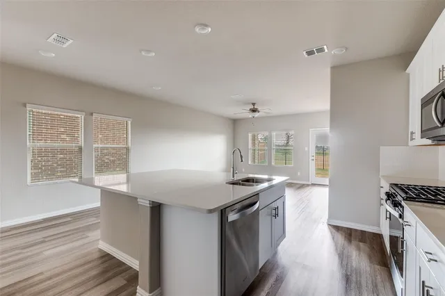 a kitchen with granite countertop a sink stove and cabinets