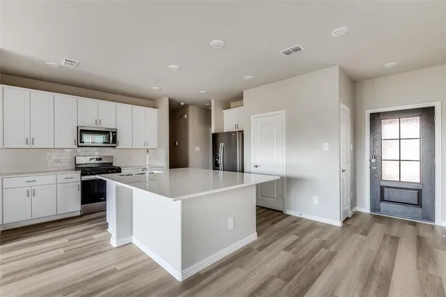 a kitchen with white cabinets and stainless steel appliances