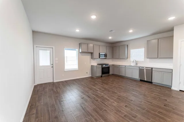a view of kitchen with wooden floor and electronic appliances