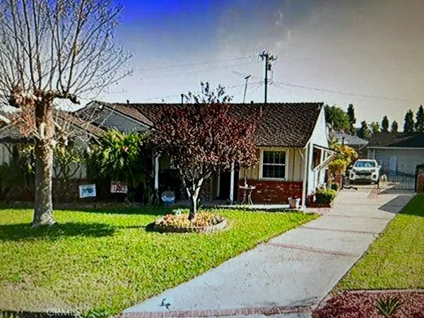a front view of a house with swimming pool and garden