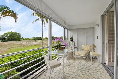 a view of a chairs and table in patio with wooden floor
