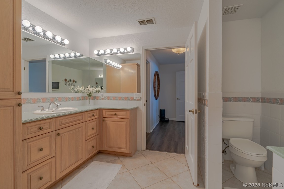 Undisclosed Address Edgewater, FL 32141 - Photo 25 of 34 a spacious bathroom with a granite countertop sink a toilet a mirror and shower