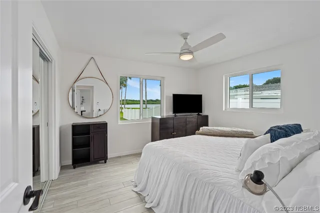 a bedroom with bed and a tv on the dresser