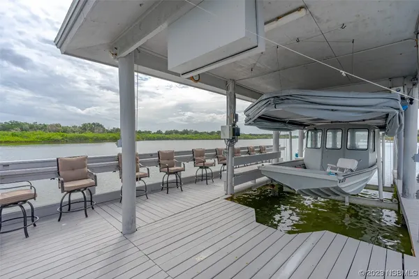 a view of a patio with couches table and chairs with wooden floor