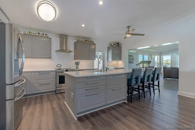 a kitchen with stainless steel appliances a stove a sink cabinets and wooden floor